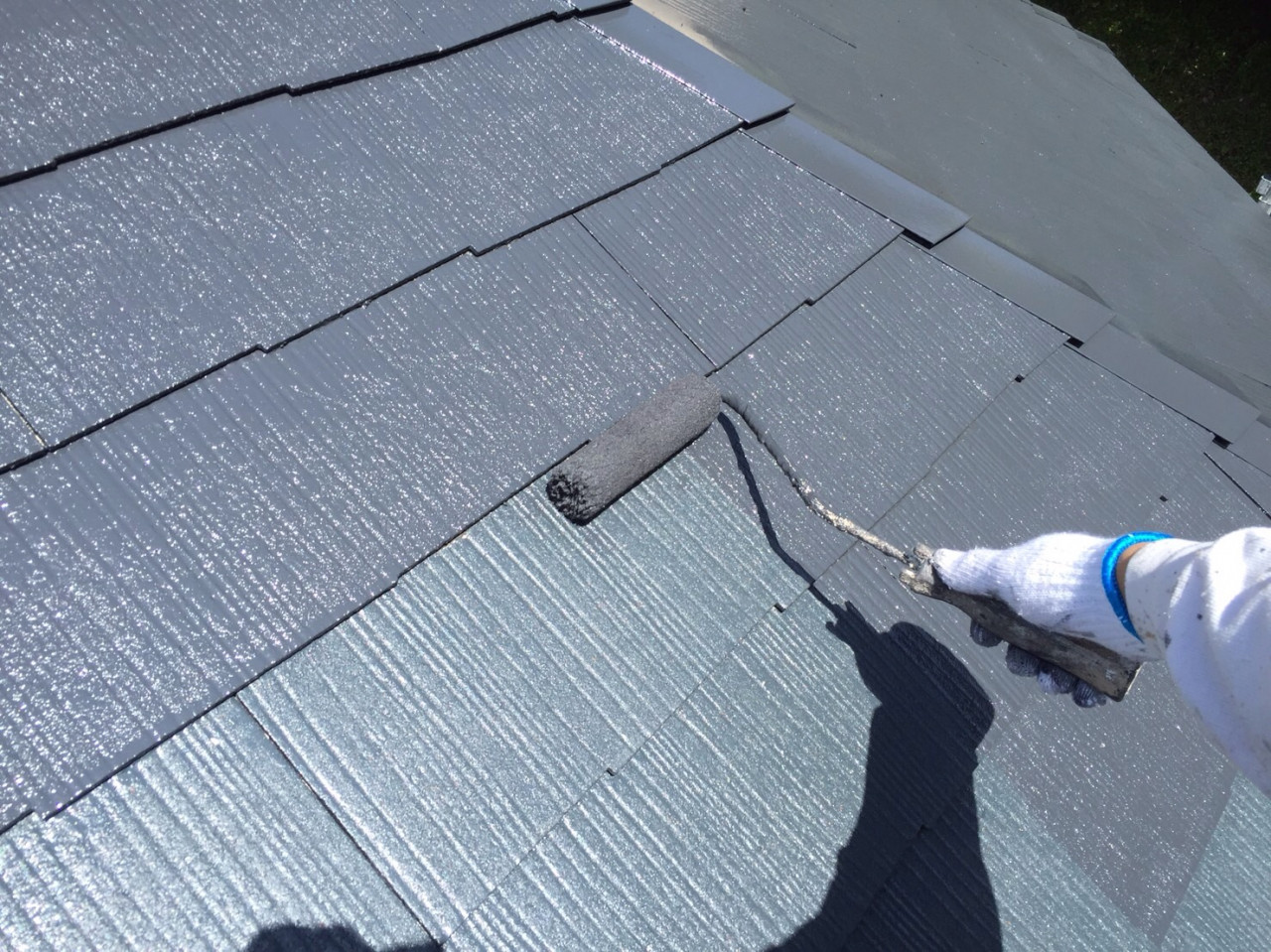 屋根の塗装する作業員
