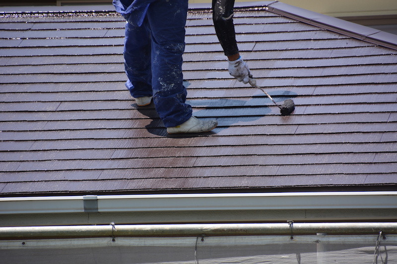 屋根塗装する作業員